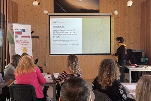A workshop setting where a speaker presents the Phoenix 4.0 EU tourism initiative to an audience on a projection screen.