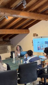 A trainer presents the principles of audio digitalisation to participants seated around a table during the theoretical part of the THRIVE Academy.